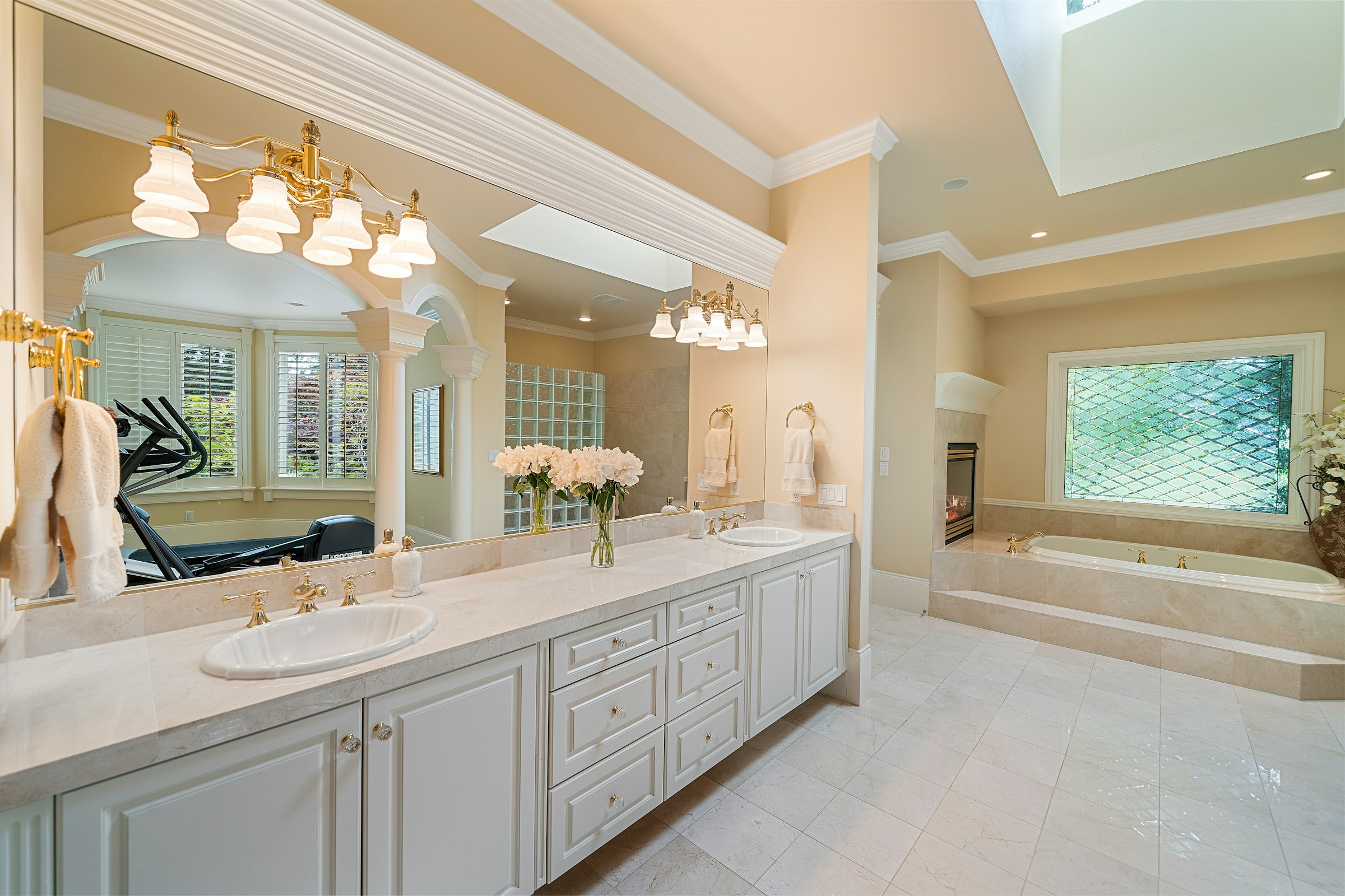 Stunning marble-effect tiled bathroom with luxury gold fixtures and freestanding bath